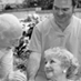 black and white photo of elderly couple with a nurse